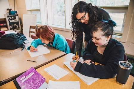 a teacher helping a middle schooler with an assignment